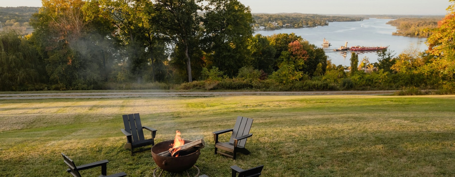 a fire pit with chairs in a grassy field