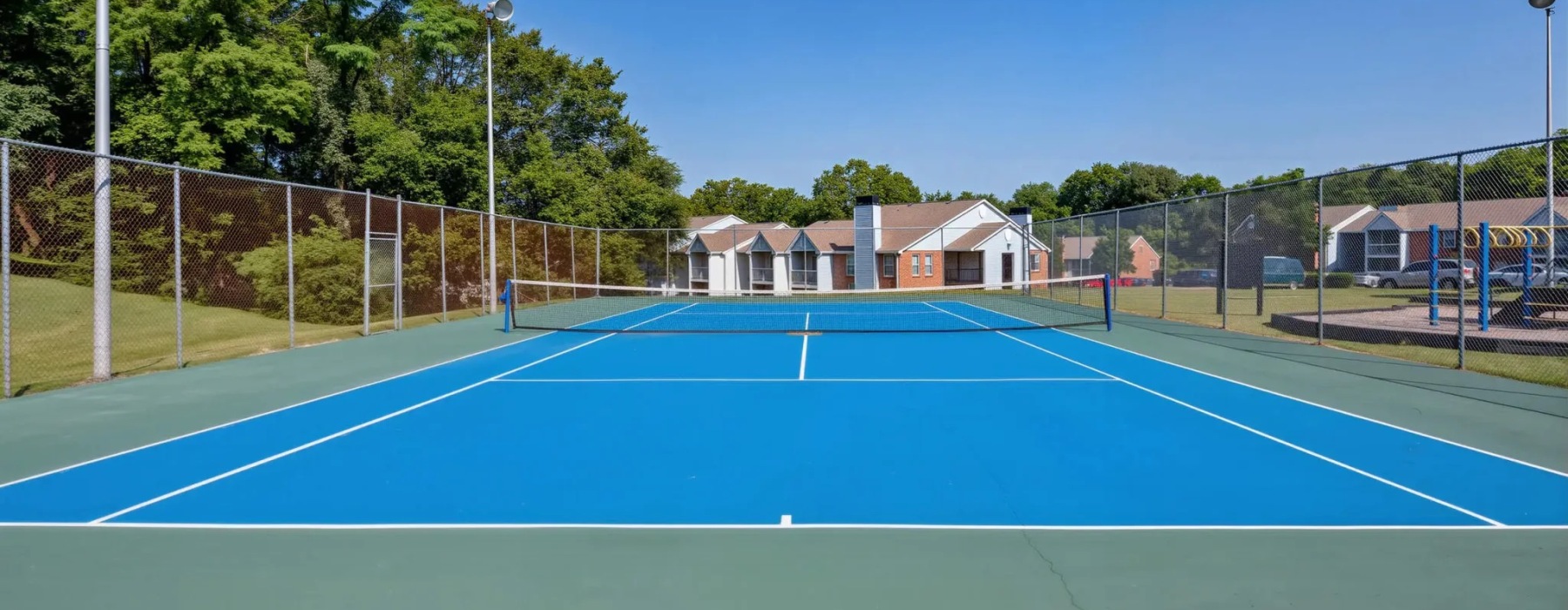 a tennis court with trees and buildings